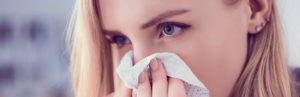 woman-blowing-her-nose-into-tissue